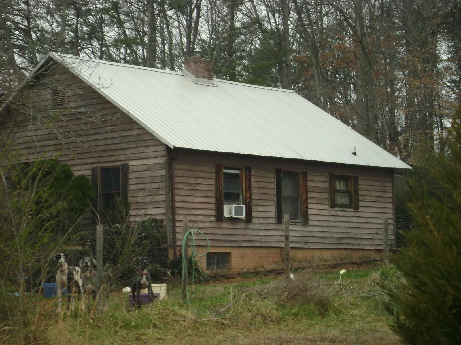 White metal roof on an old wood sided farmhouse, from a Metal Roof Installation job in Tupelo